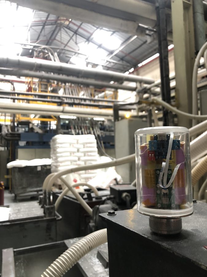 Sensor node in a clear cylindrical housing magnet-mounted on machinery in a plastics plant